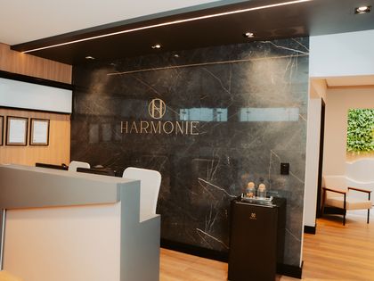 Balcão de recepção em mármore, com o logotipo da Harmonie
