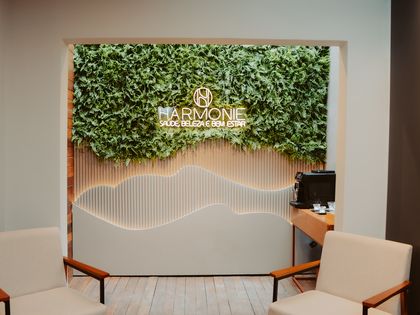 Recepção da Harmonie, com parede viva, poltronas e o letreiro