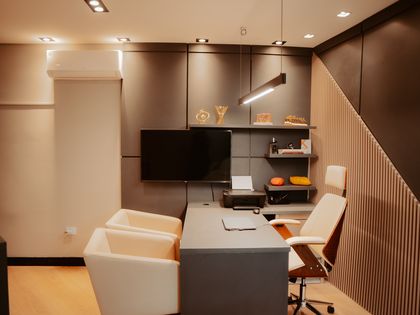 Consultório da Harmonie, com mesa, poltronas e prateleiras